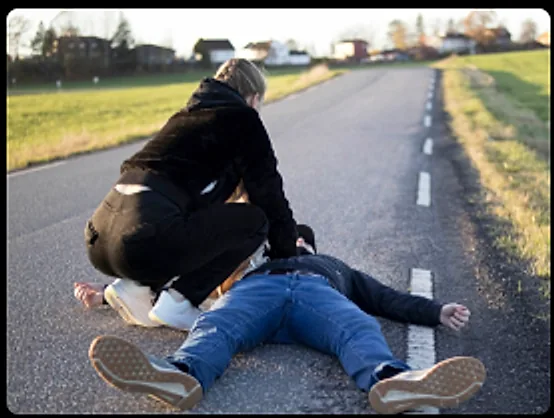 A bystander performing chest compressions on a collapsed adult at the roadside